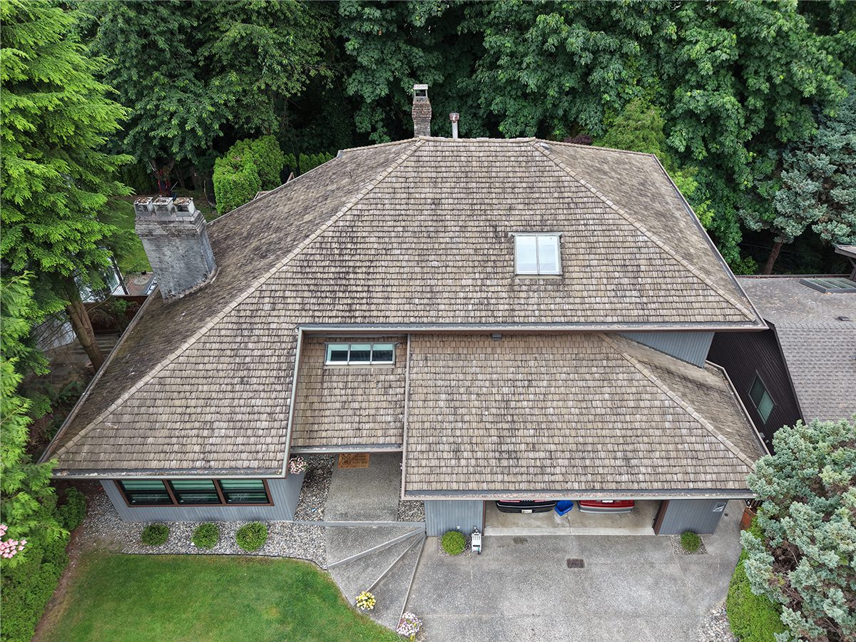 Before: aging cedar shake roof prior to replacement
